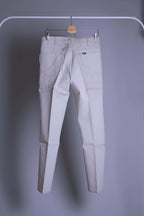 NOS Vintage Lee Leens Lastic Stretch trousers in beige color, back view, hanging on a metal rack.