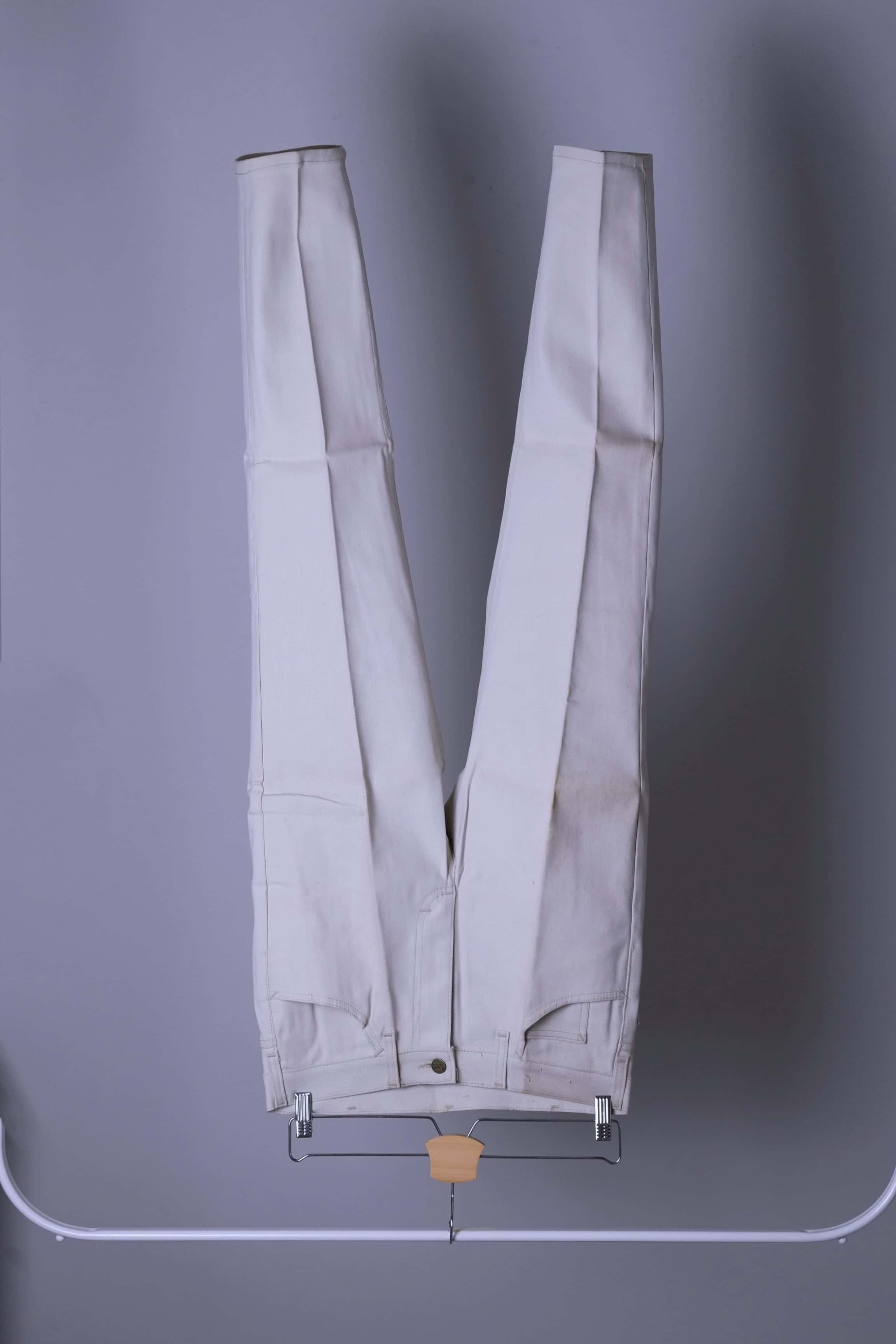 NOS Vintage Lee Leens Lastic Stretch trousers in beige color, front view, hanging on a metal rack.