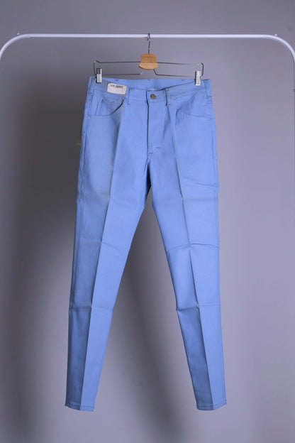 Front view of NOS 70s Lee Leens Lastic Stretch denim trousers in light sky blue, shown hanging on a rack.