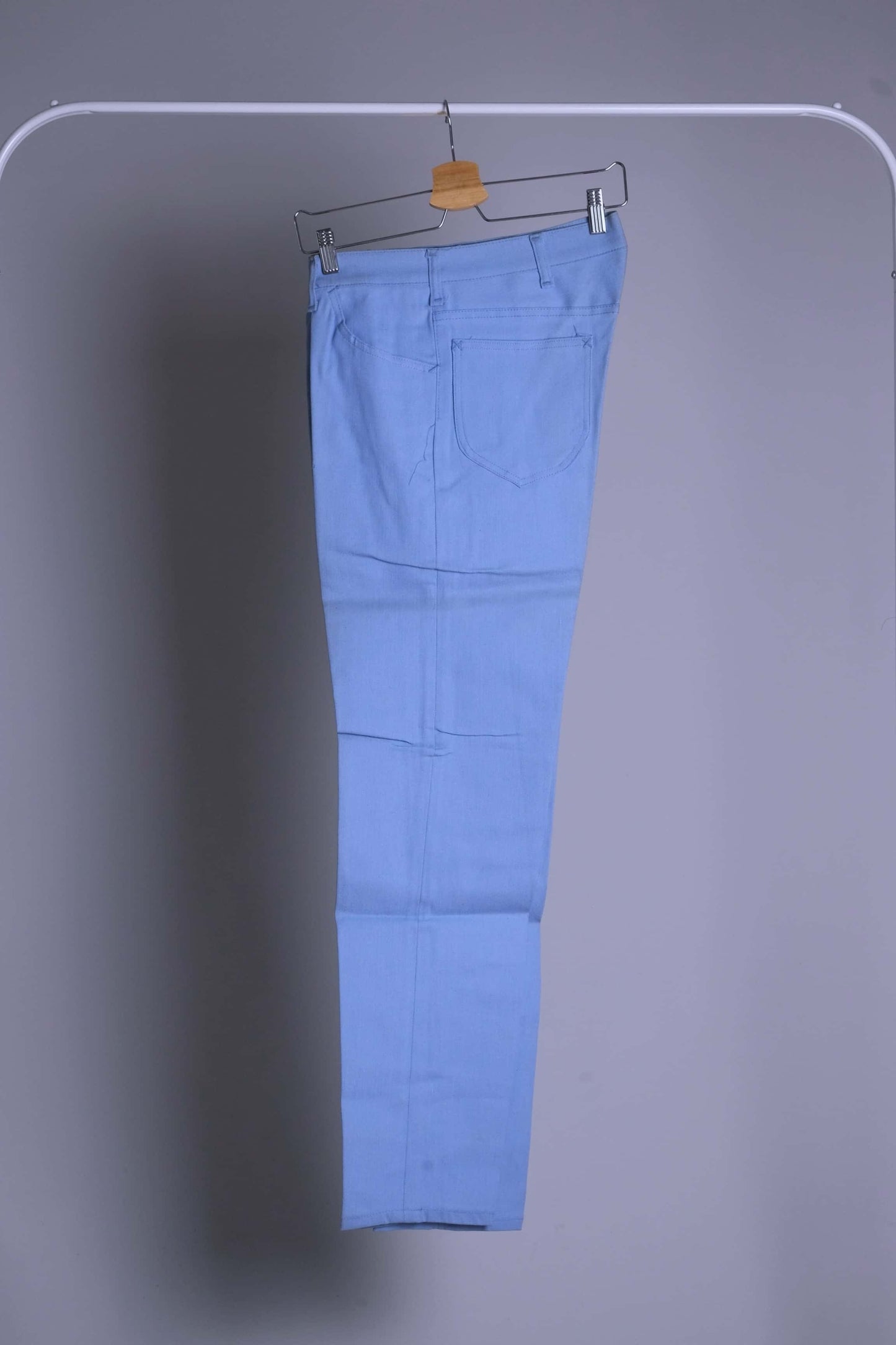 NOS 70s Lee Leens Lastic Stretch denim trousers in light sky blue, shown folded and hanging on a rack.