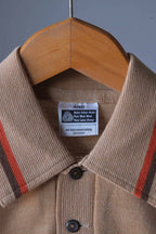 Close-up shot of the collar, buttons, and Woolmark pure new wool tag on a vintage beige knit polo sweater.