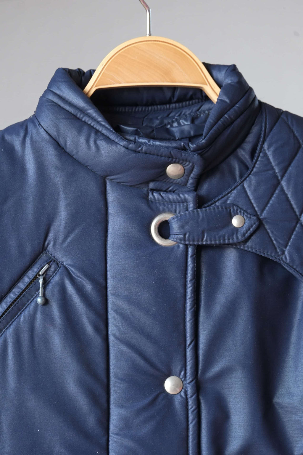 Close up view of Vintage navy 2-piece ski suit on hanger