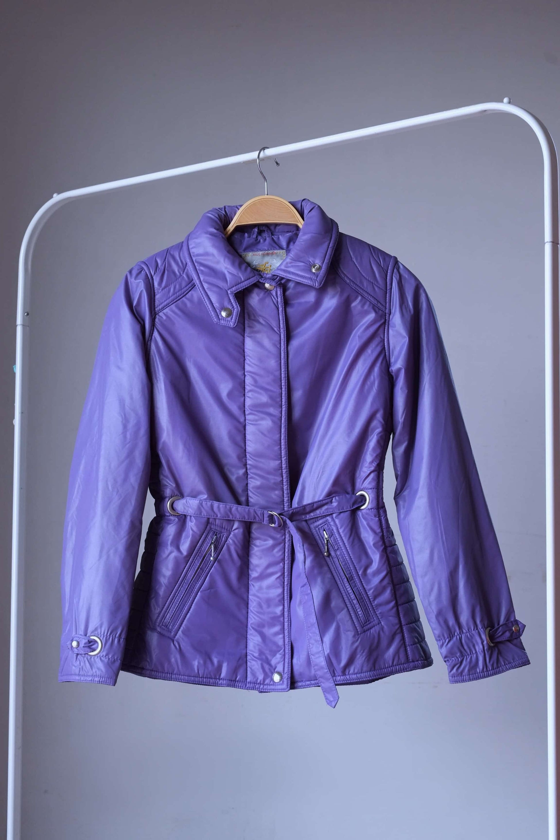 Purple jacket of Vintage 70s women 2-piece ski suit on hanger